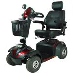 Scooter (Rosso) di medie dimensioni, sedile con numerose regolazioni: schienale, poggiatesta, larghezza e altezza braccioli, seduta - piantone dello sterzo regolabile - ruote a fianco alto per tutti i fondi stradali.